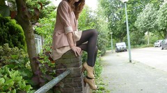 Wall woman sitting suit sunglasses legs stockings outdoors 