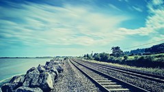 Water ocean rocks skies railroad tracks