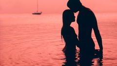 Water silhouettes kissing couple
