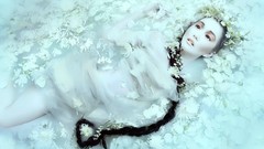 Water woman white flowers braids white dress models lying down 