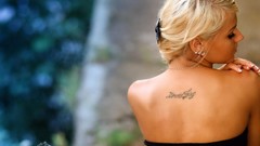 Woman back faces shoulders blondes tattoos looking back