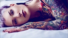 Woman beds tattoos lying down