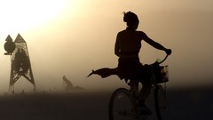 Woman Bicycles burning man