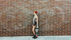 Woman blondes brick wall skateboards
