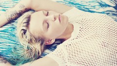 Woman blondes tattoos closed eyes lying down nipples no bra