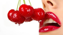 Woman close-up lips wet cherries red lipstick Simple Background