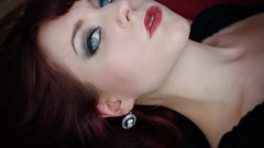 Woman earrings gray eyes green eyes lying down red lipstick 