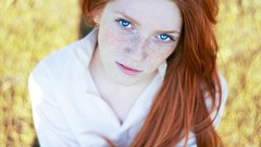 Woman faces blue eyes freckles redheads blurred background 