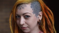 Woman faces dreadlocks tattoos piercings orange hair