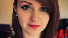 Woman faces green eyes freckles red lipstick dimples