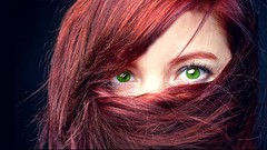 Woman faces green eyes redheads hair in face