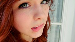 Woman faces redheads biting lips