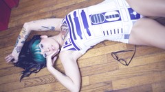 Woman glasses star wars tattoos piercings green hair lying down 