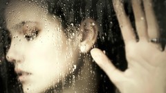 Woman hands looking down rain on glass