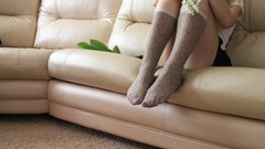 Woman Headless sitting legs couch knee socks strategic covering 
