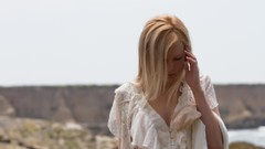 Woman looking down blondes Brea Bennett white shirt