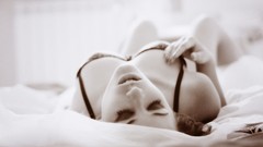Woman monochrome lingerie closed eyes lying down cleavage