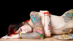 Woman mushrooms rings earrings tattoos piercings lying down 