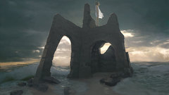 Woman ocean clouds ruins