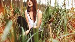 Woman sitting outdoors smiling looking up