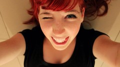 Woman smiling blue eyes wink lying down redheads self shot