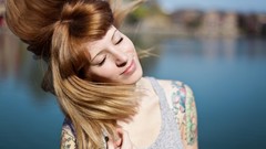 Woman tattoos smiling closed eyes
