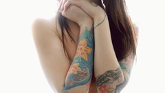 Woman tattoos topless holding boobs