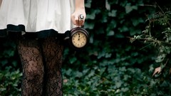 Woman watches clocks legs white dress