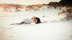 Woman white sand white dress lying down