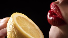 Yellow close-up lips black background fingers lemons lipstick