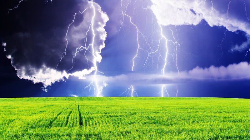 Thunderstorm over green field