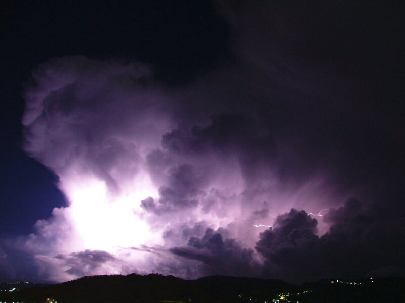 Thunderstorm over hills at night