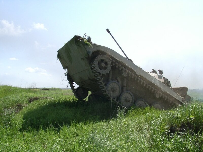 Tilted military tank in field