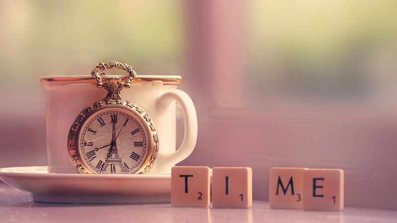 Time concept with pocket watch and scrabble tiles