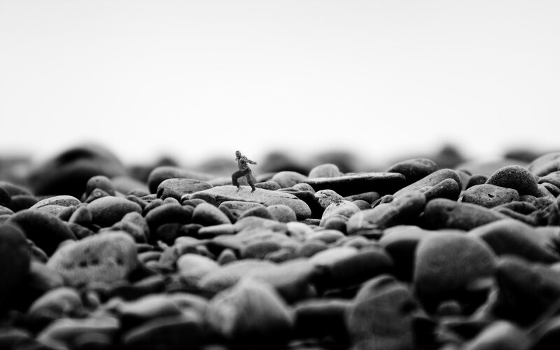 Tiny figure on rocky shore