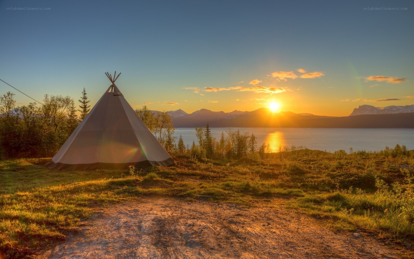 Tipi tent at sunset by lake