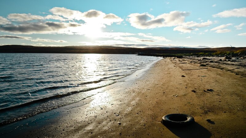 tire on a beach at sunset