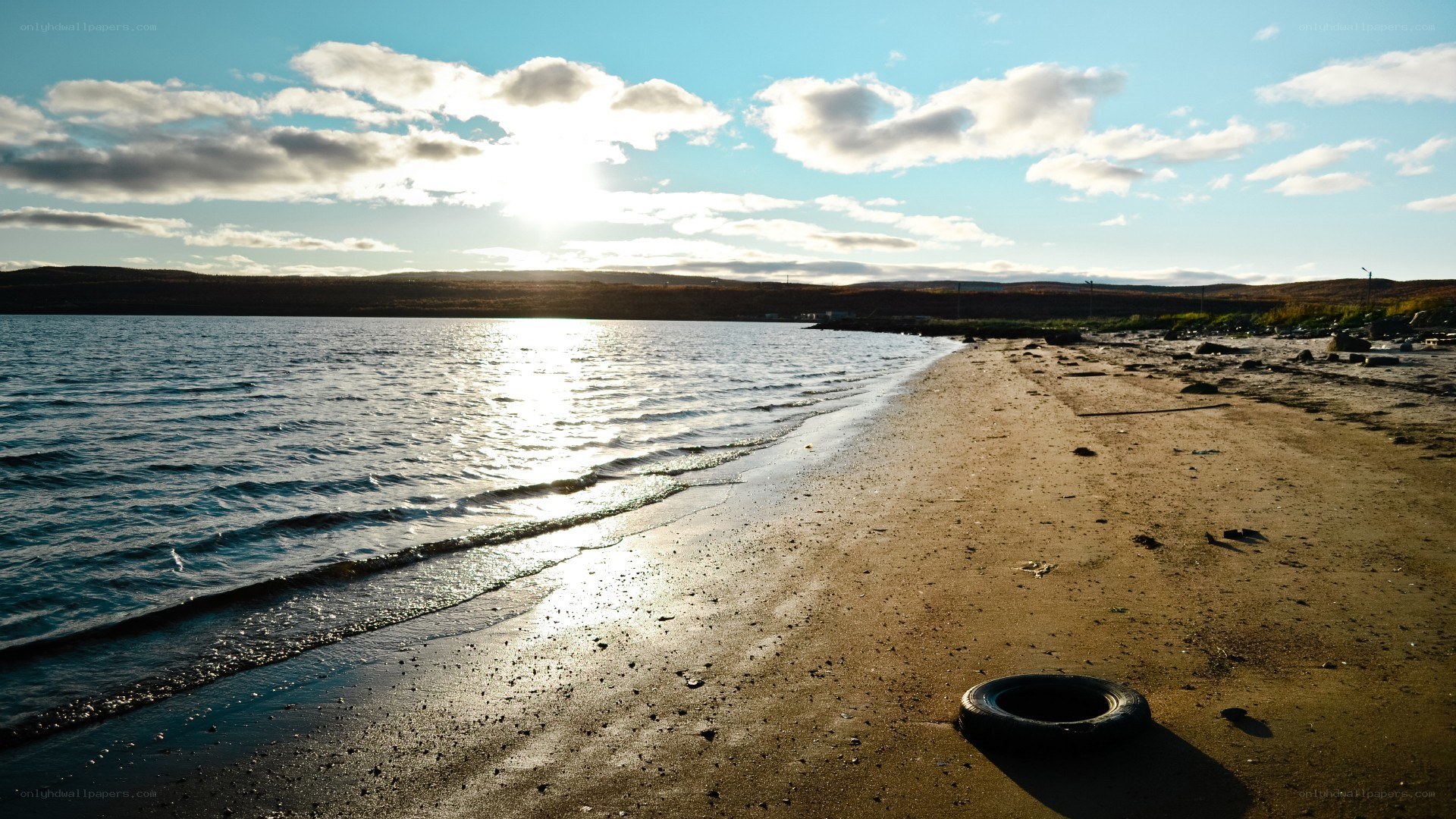 tire on a beach at sunset