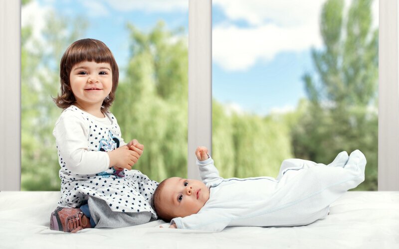 Toddler and Baby on Bed