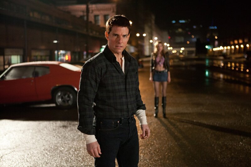 Tom Cruise on a wet street at night