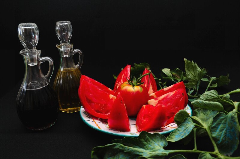 Tomatoes and oil on black