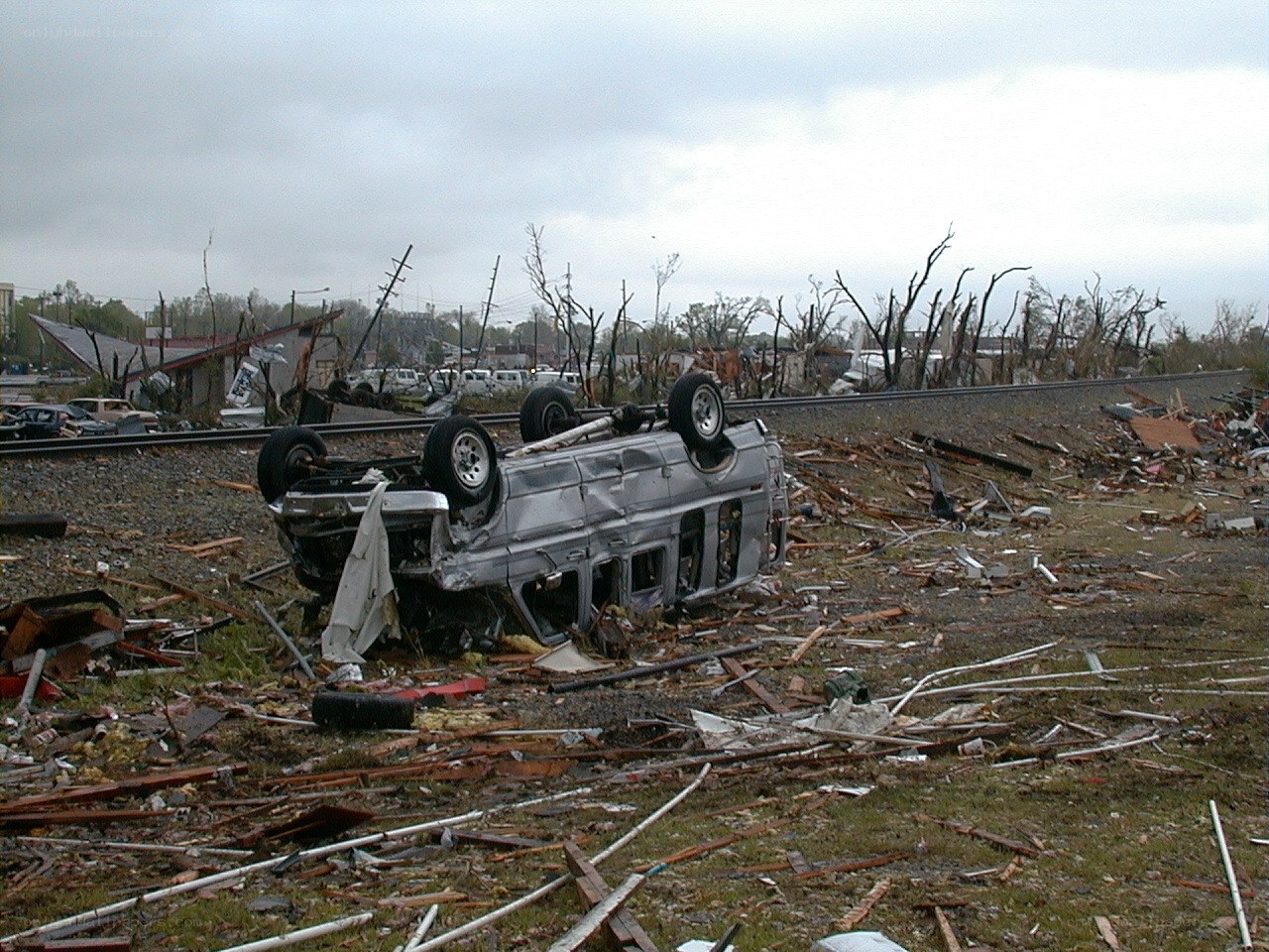 Tornado damage scene with overturned vehicle