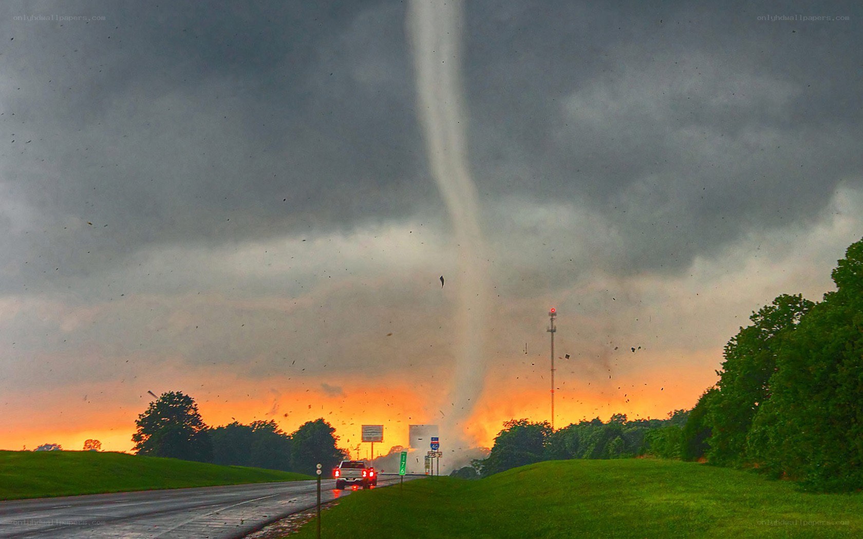 Tornado over a highway at sunset