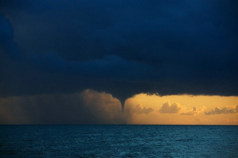 Tornado over the ocean at sunset