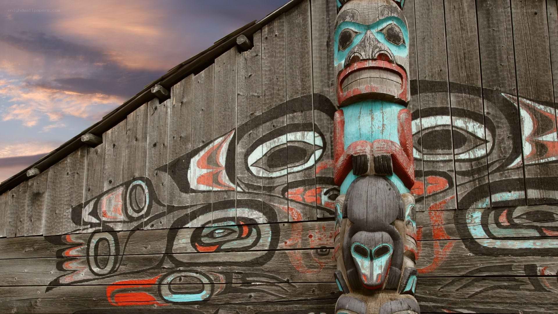 Totem pole and mural at dusk