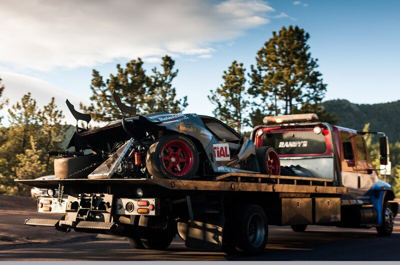 tow truck carrying damaged race car