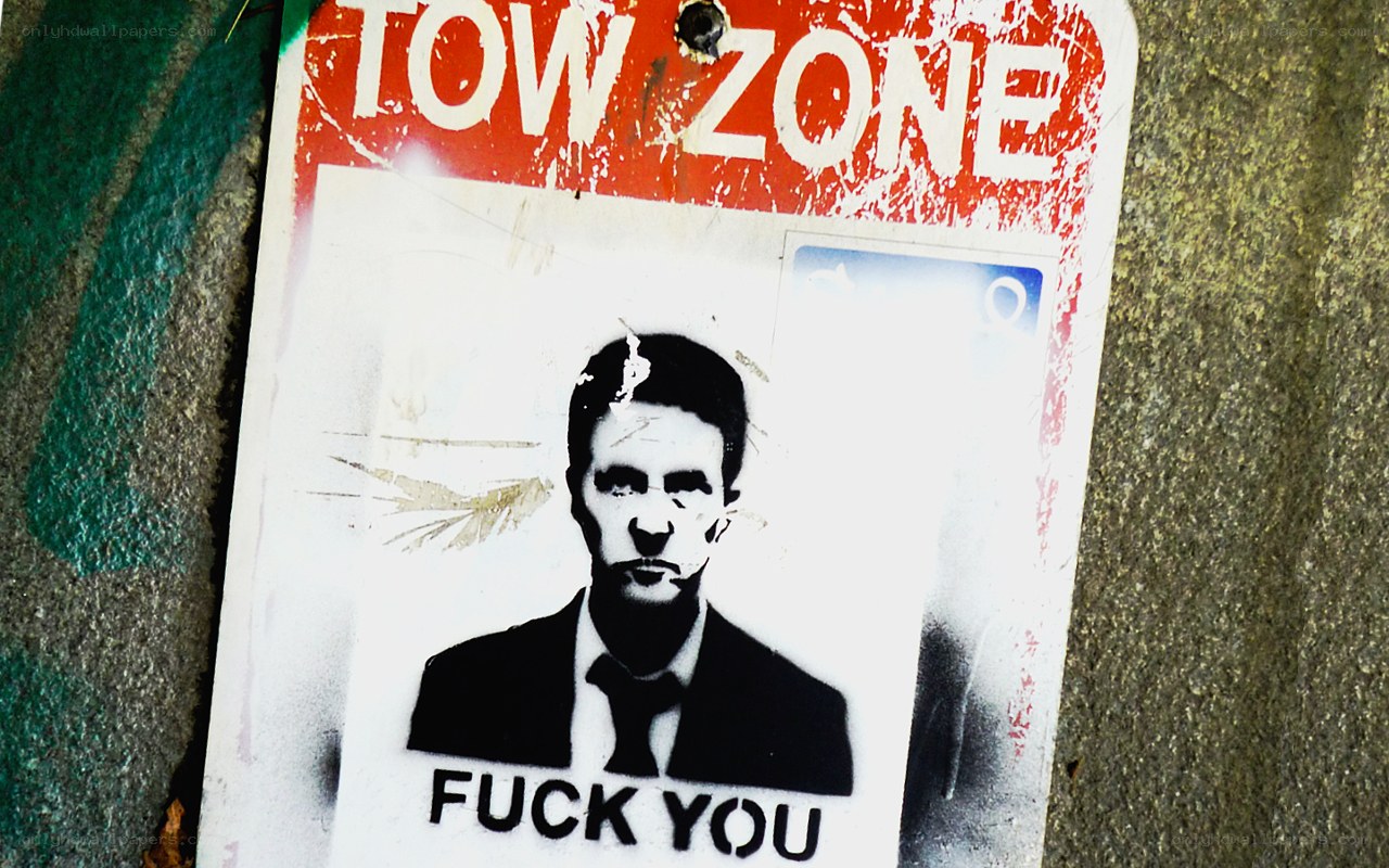 tow zone sign with graffiti