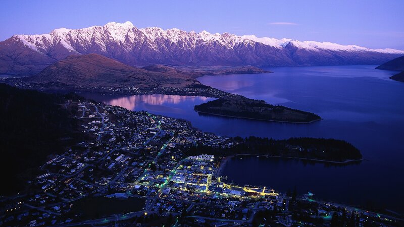 Town by lake with snow-capped mountains