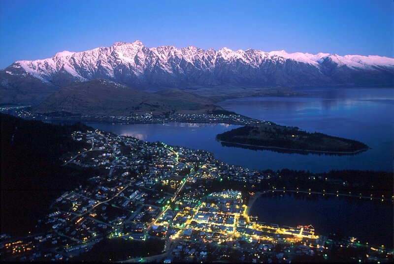 Town by lake with snow-capped mountains