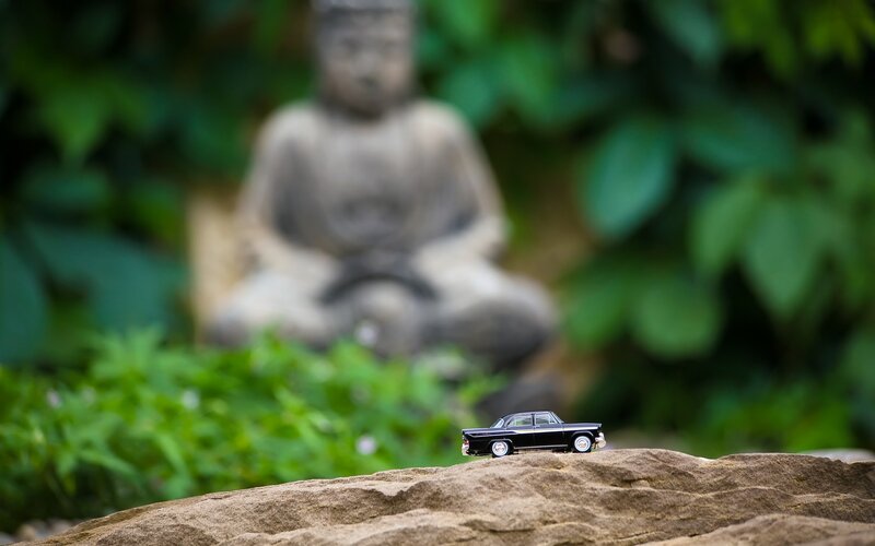 Toy car on a rock with Buddha statue